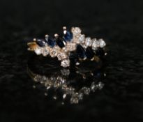 An 18ct gold sapphire and diamond crossover ring. The sapphires interspersed with diamonds, all