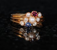 An 18ct gold ruby, sapphire, pearl and diamond ring. The centre set pearl surrounded by ruby and