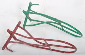 A pair of painted (red and green) tubular metal saddle racks by Stubb of England. Measures 54 cms