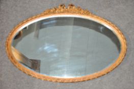 A gilt oval mirror.