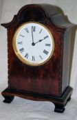 A small arched mantel clock with circular movement and platform escapement