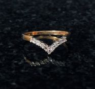 A 9ct gold ladies channel set diamond ring mounted within a wisahbone shaped hoop