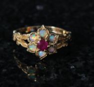 A 9ct gold ladies ruby and opal ring. The centre set opal surrounded by rubys and mounted to a