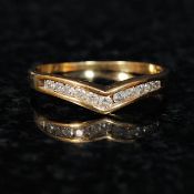An 18ct gold ladies channel set diamond wishbone ring. The wishbone gold ring having inset diamond