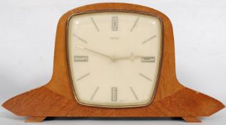 A Smiths 1950`s retro mantle clock on mahogany case with minimalist face having a brass movement