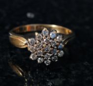 A ladies 9ct gold diamond cluster ring. The centre set diamonds mounted to a plain gold hoop with