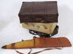 A collection of suitcases together with an attache case and a canvas guncase