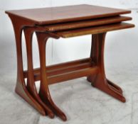 A 1970`s retro teak wood nest of tables. The shaped legs united by stretchers to the rear