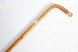 A 20th century fruitwood walking stick cane with gold plated band and tip.