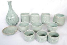 A part Chinese green Celadon crackle glaze tea set in with markings to base. To include bowls, vase