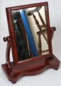 A Victorian mahogany toilet mirror on serpentine base, scrolled arms with swing mirror and bamboo