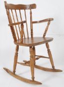 A Victorian pine rocking Windsor chair on sleigh runners, turned legs and a spindle back rest.