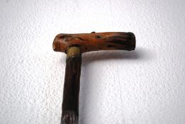 A 20th century carved wooden walking stick / cane with rustic carved handle and band.