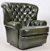 A Green antique style Chesterfield armchair. The unusual wing backed shaped chair having seat to