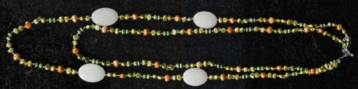 A long pearl necklace with jade spacers.