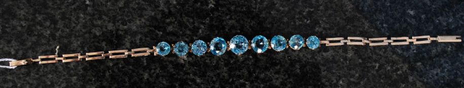 A yellow gold bracelet set with blue topaz.