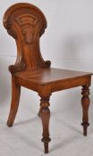 A Victorian carved oak hall chair. Raised on turned legs with panelled oak seat having a shaped