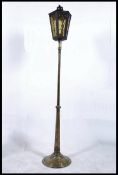 A large Victorian brass standard lamp in the form of a street lamp with glass lantern top and