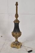 A 20th century antique style brass lamp being wired for electricity having bulbous body with