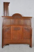 A 1930`s French Art Deco oak double bed. The head and footboard united by sleigh runners, carved