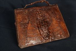 A mid 20th Century alligator skin ladies clutch handbag. Fold over snap detailed with head to