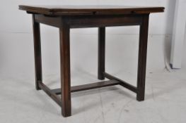 An Ercol dark oak Jacobean revival draw leaf refectory dining table. Square legs united by