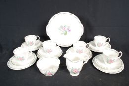 A Susie Cooper part tea service in a floral pattern comprising cups saucers, milk and sugar. All