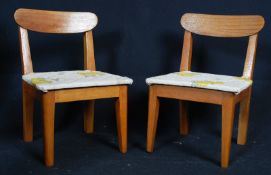 A pair of retro 1970`s teak wood apprentice piece dining chairs. Raised on tapered legs with period