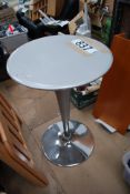 A silver bistro table with adjustable height.