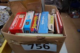 A box of assorted vintage jigsaw puzzles and books.