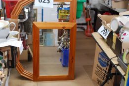 A large pine framed mirror along with one other smaller mirror