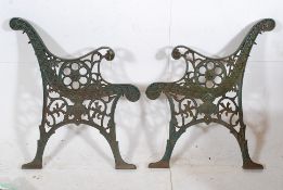 A decorative pair of cast iron fret worked bench ends, painted green, circa 20th century