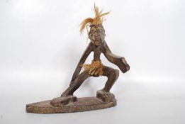 An African figure of a man surfing. (Said to have been brought to the UK in the 1950`s. It is