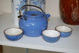 A crackle glaze tea pot along with three tea bowls.