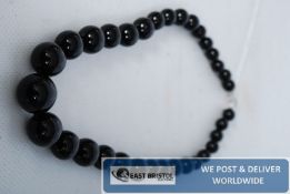 A row of graduated marble beads with heart clasp.