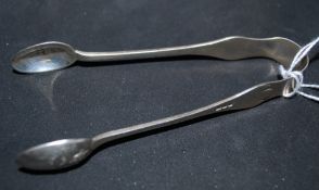 A pair of silver sugar tongs being hallmarked for London 1897 by Samuel Jacob. The tongs bowls