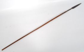 An African tribal short spear. The polished short shaft having a bound arrow head with barbed