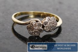A ladies 18ct gold & diamond crossover daisy ring. The centre set flower heads with diamonds