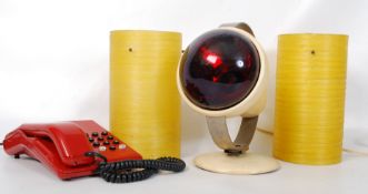 A retro health lamp along with a retro red telephone and two resin plastic lamp shades.