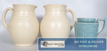 A pair of Arthur Wood jugs (20cm) and one other.