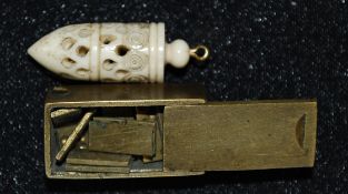 A carved bone bullet shaped pendant with screw top containing miniature dice, miniature brass cased