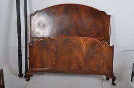 An Edwardian flame mahogany double bed. The cabriole legs with pad feet supporting head and