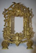 A Victorian brass fret worked cherub photo frame / easel picture frame.