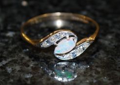 A 9ct gold ladies crossover diamond and fire opal ring. The cross over 9ct gold hoop having