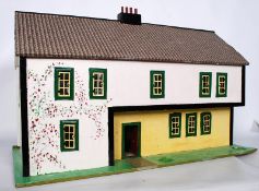 A large vintage wooden toy dolls house, with metal doors and windows etc.