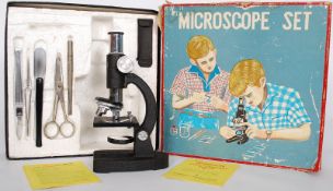 A vintage cased childs microscope with instructions, slides etc.