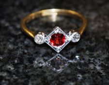 An 1920's Art Deco 18ct platinum ruby and diamond ring. The lozenge shaped centre with ruby stone to