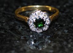 An 18ct gold claw set diamond and emerald solitaire ring. The central emerald stone having diamond