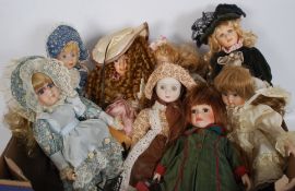 A collection of ceramic dolls of varying forms, all clothed and of decorative design