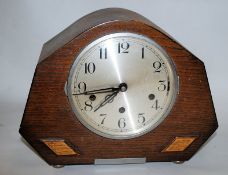 A 1930's Art Deco westminster chime mantle clock. The angular case having circular face with